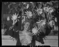 Carolyn Briggs posing with night blooming cereus flowers, Santa Monica, 1934