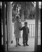 Children on porch looking through open door, Los Angeles, circa 1935