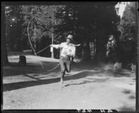 Rodeo performer Tex Young doing rope trick, Lake Arrowhead Rodeo, Lake Arrowhead, 1929