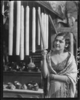 Sally Lang with hanging candles at merchant stand, Los Angeles, 1931