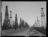 Oil well drilling rigs along Pacific Coast Highway, Huntington Beach, 1929