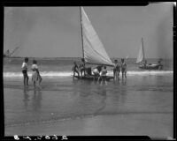 Sailboat surrounded by crew on the shore during Regatta Week, Santa Monica, 1934