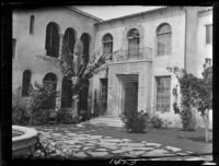 Courtyard of 2-story house with arched windows, Santa Monica, 1928