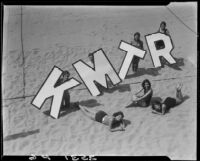 Young women on beach promoting radio station KMTR, Santa Monica, [circa 1930]