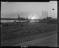 Harbor, oil well drilling rigs, boats, and buildings at sunset, Newport Beach, Laguna Beach, or Long Beach, 1929