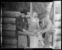 Men building log cabin, San Bernardino, 1925-1928
