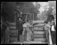 Men building log cabin, San Bernardino, 1925-1928