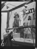 William Gibbs McAdoo standing on scaffolding working on billboard, Los Angeles, 1925 or 1927