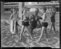 Identical triplet sons of politician George W. Neal playing on the beach with other children, Santa Monica, circa 1930's