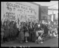 William Gibbs McAdoo and group posing with billboard advertising Golden Rule Week at Golden Rule Foundation Pageant, Los Angeles, 1930