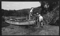 Guide Captain Drysdale helps filmmaker Paul Rotha party board a boat during a journey to Murchison Falls, Uganda, 1933