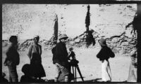 Filmmaker Paul Rotha, with Margaret Rotha and local men, filming next to an ancient wall, Baghdad, 1932