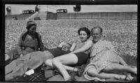 Filmmaker Paul Rotha and 2 women and 1 man sunbathing, England, 1932-1933