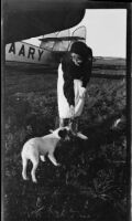 Dog taking a stick from woman after the forced landing of a transport plane, Kigwe, Tanzania, 1932