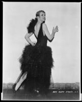 Peggy Hamilton modeling a dress with a jet bead bodice and skirt of layered black silk net ruffles, 1928