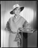 Peggy Hamilton modeling a dress of beige crepe with striped sash and sleeves, 1933