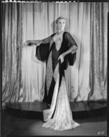 Peggy Hamilton modeling an evening gown in dark chiffon and light lace, 1930