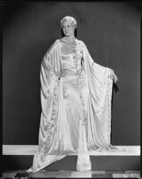 Peggy Hamilton modeling a Travis Banton "Grecian" style hostess gown of moonbeam satin, 1931