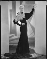 Peggy Hamilton modeling a Max Rée gown of black velvet with a collar in white beads emulating lace, 1932