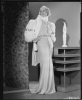 Peggy Hamilton modeling an evening gown with wide fur sleeves, 1933