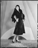 Peggy Hamilton modeling a black calf-length fur coat and a hat, 1929