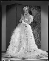 Peggy Hamilton modeling a Travis Banton gown with a full skirt of white tulle accented with gardenias, 1933