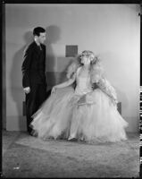 Peggy Hamilton modeling an Adrian tulle evening gown with the designer at her side, 1929