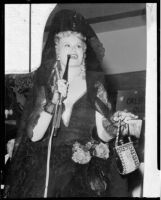 Peggy Hamilton wearing a Spanish costume and speaking into a microphone as "Queen of Fiesta," Ontario, circa 1931