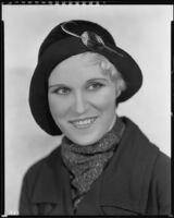 Peggy Hamilton modeling a hat with a velvet crown and a feather ornament, circa 1931