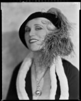 Peggy Hamilton modeling a dress or coat with light fur trim and a hat trimmed with an ostrich feather, circa 1931