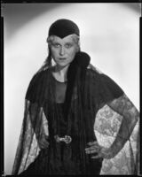 Peggy Hamilton modeling a cap with a velvet chin strap and a net veil, 1933