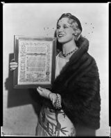 Peggy Hamilton holds plaque awarded to her by Lions Club for her service as official hostess, Los Angeles, 1932