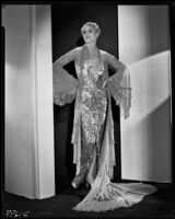 Peggy Hamilton modeling a Travis Banton hostess gown with beaded chiffon and gold lace, 1932