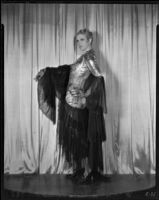 Peggy Hamilton modeling a gown with a figured silk bodice and dark, sheer tiered skirt, circa 1931