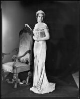 Woman modeling an evening gown of jacquard pattern silk, circa 1928-1933