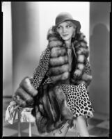 Actress Noel Francis modeling a fur coat, circa 1931-1933