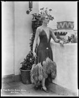 Peggy Hamilton modeling a gown in red chiffon accented with scattered rhinestones and an ostrich feather hem, 1928
