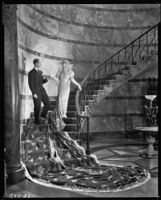 Peggy Hamilton modeling a Max Rée gown as "Queen Olympia" with a companion (probably the designer Adrian) at her side, 1931