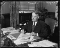 Los Angeles Mayor Frank Shaw at desk with papers, Los Angeles, 1933-1938