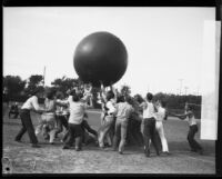 Young men playing with large exercise ball at homecoming "brawl," University of Southern California, Los Angeles, [1928?]