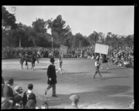 Men with signs referring to the Rose Bowl game between the Pittsburgh Panthers and the USC Trojans in the Tournament of Roses Parade, Pasadena, 1930