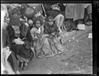 Boy and girl with curb-side seats for the Rose Parade, Pasadena, 1930