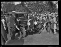 Crowd of Rose Parade spectators next to an ambulance, Pasadena, 1930