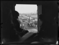 View towards the Rose Parade from upper floor window of parade route building, Pasadena, 1930