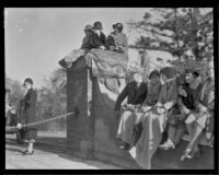 Spectators seated on a stone wall at the Tournament of Roses Parade, Pasadena, 1932