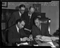 Buron Fitts, Percy Starmmon, and Herbert Payne watch as Elliot B. Thomas signs a check, Los Angeles, 1932