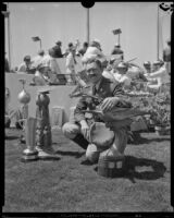 Col. Roscoe Turner resting hand on aviation trophy, Los Angeles, 1930s
