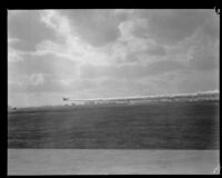 U.S. Army biplane releasing smoke screen during air show at United Airport in Burbank, 1930.