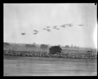 Biplanes fly in formation over spectators at United Airport in Burbank, 1930.