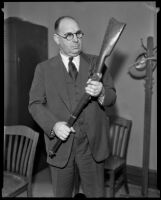 Captain Bert Wallis examining butt of rifle, Los Angeles, 1930s